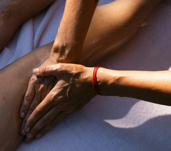 Massage administré sur la cuisse d'une personne couchée