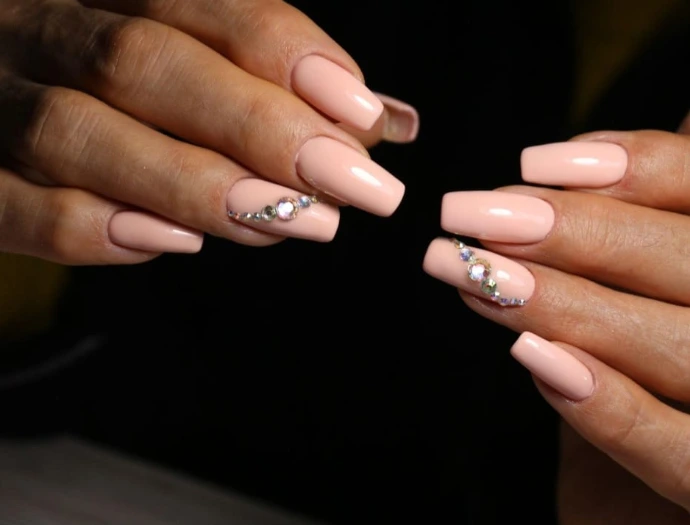 Ongles longs vernis en rose avec des strass